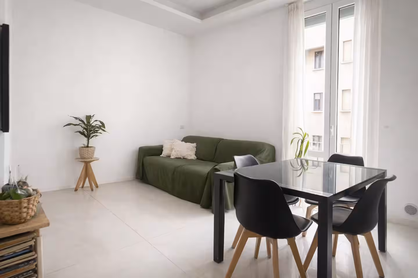 Living room with green sofa and dining table – Edera Apartment, Isola, Milano